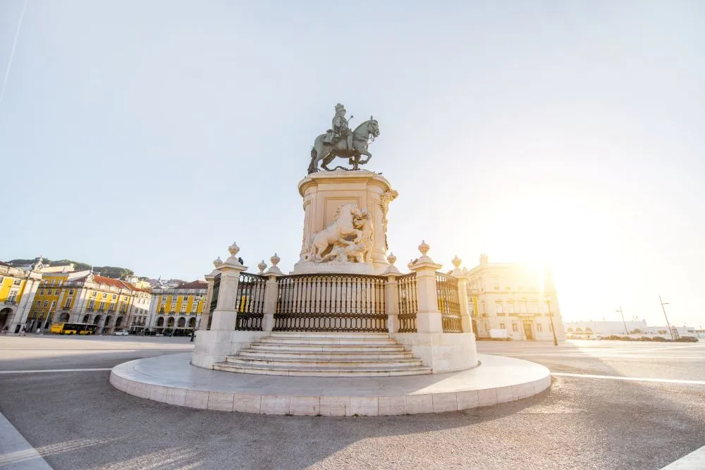 Statue of King José I in Praça do Comércio, Lisbon’s grand riverside square, glowing in the early morning sunlight.